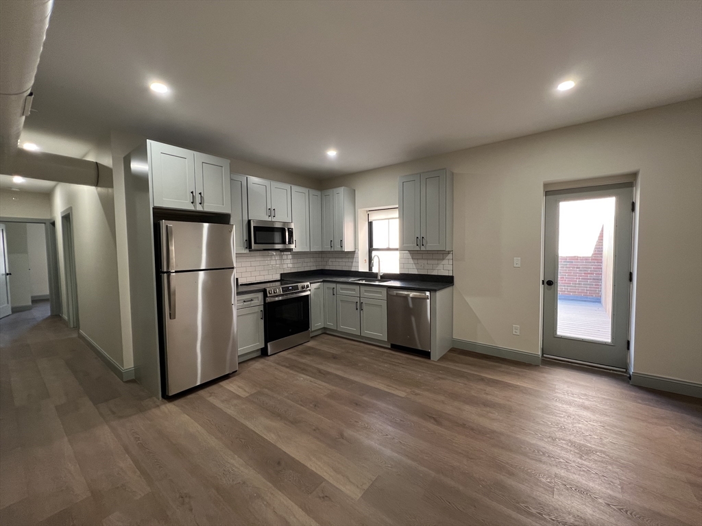 a kitchen with granite countertop a refrigerator and a sink