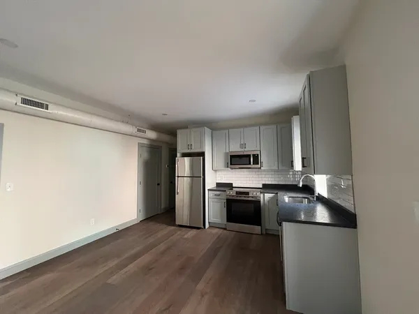 a kitchen with stainless steel appliances a sink a stove a refrigerator and cabinets