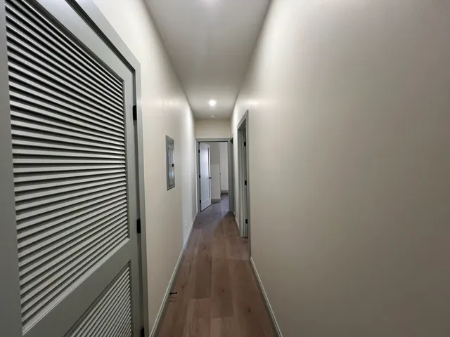 a view of a hallway with wooden floor