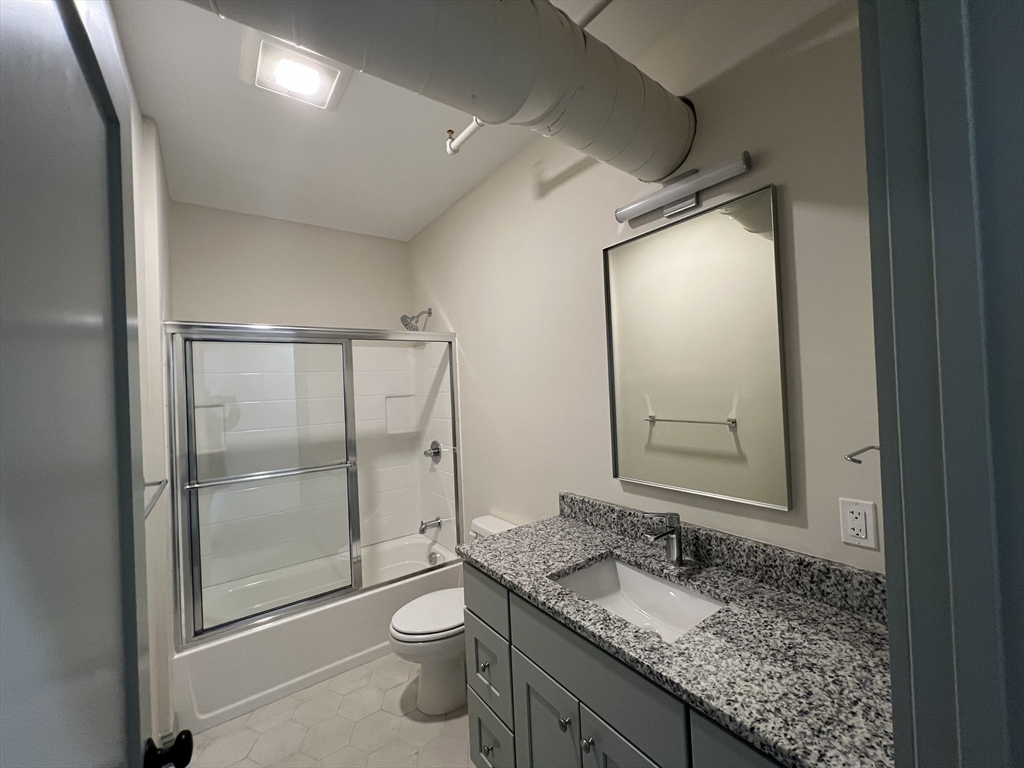 160 Seabury Street, Unit 10 Fall River, MA 02720 - Photo 8 of 11 a bathroom with a granite countertop sink toilet and shower