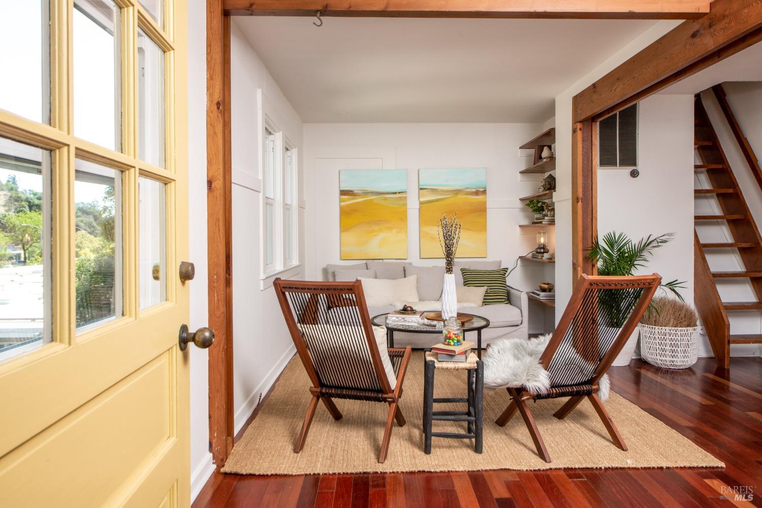 a view of a dining room with furniture a potted plant and wooden floor