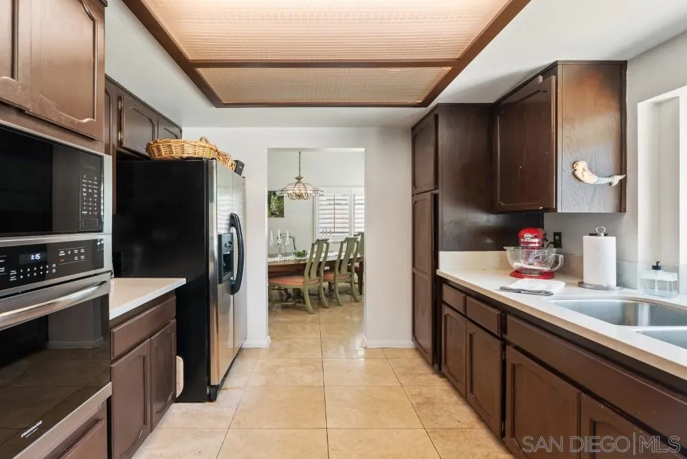 13227 Treecrest Street Poway, CA 92064 - Photo 11 of 32 a kitchen with stainless steel appliances a sink dishwasher stove refrigerator and cabinets