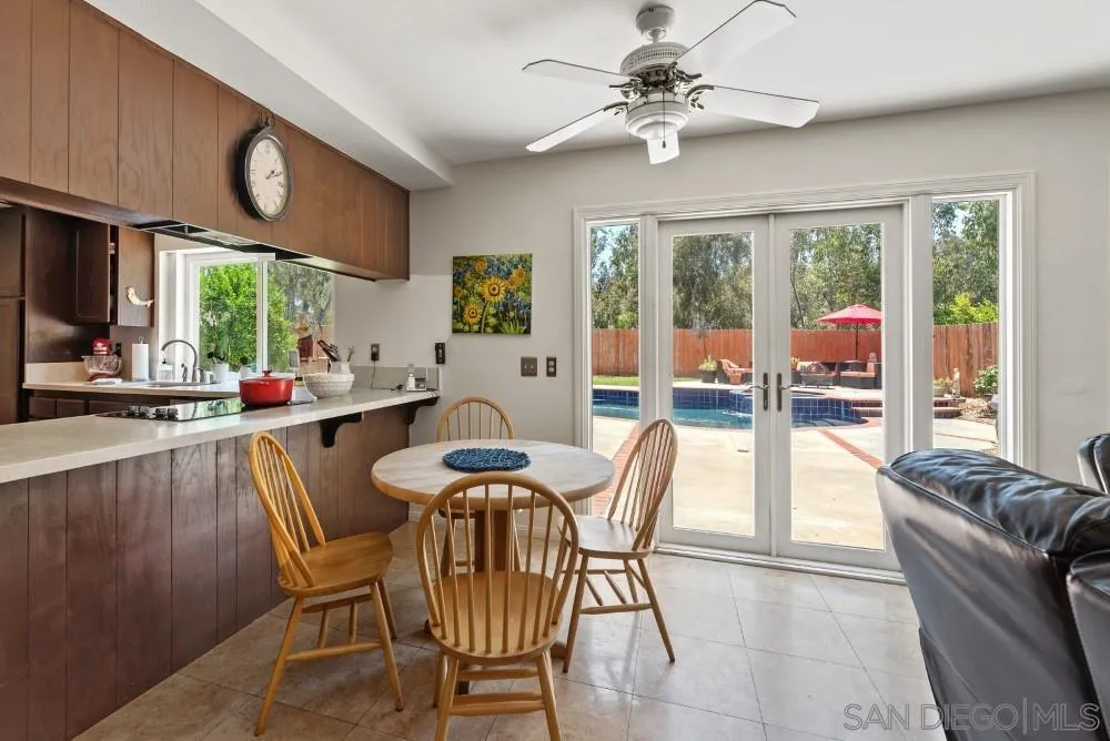 13227 Treecrest Street Poway, CA 92064 - Photo 13 of 32 a view of a dining room with furniture a chandelier and large windows