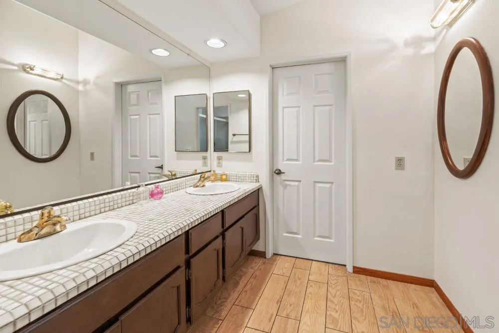 13227 Treecrest Street Poway, CA 92064 - Photo 22 of 32 a bathroom with a granite countertop double vanity sink and a mirror