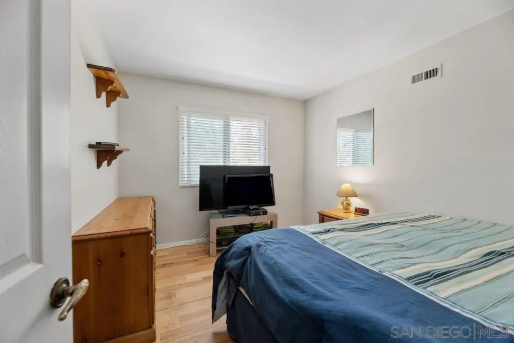 13227 Treecrest Street Poway, CA 92064 - Photo 24 of 32 a bedroom with a bed and wooden floor