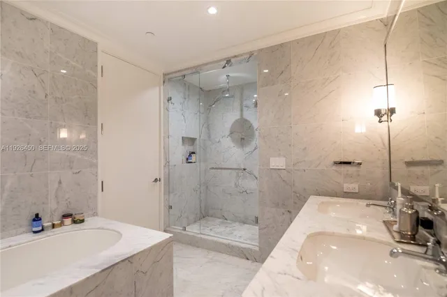 a bathroom with a tub sink mirror and a shower