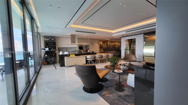 a living room with lots of furniture and a kitchen view