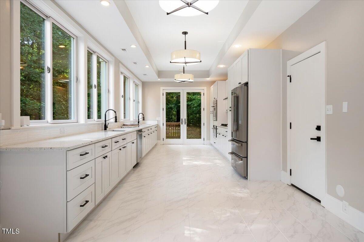 6300 Swallow Cove Lane Raleigh, NC 27614 - Photo 20 of 67 a large white kitchen with granite countertop a large white kitchen oven a sink and dishwasher with large windows