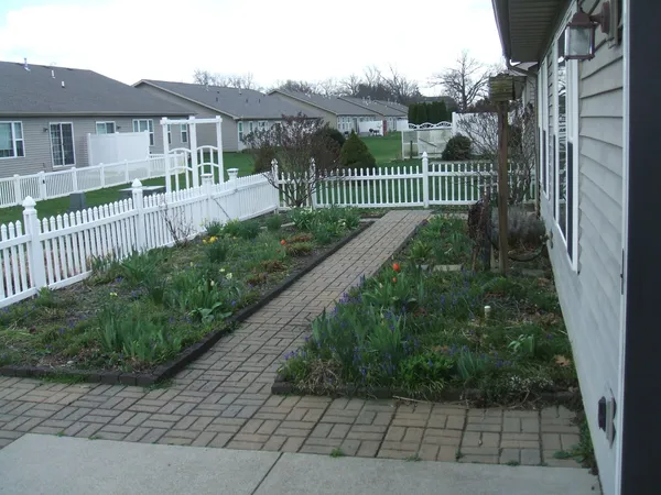 a view of a house with a small yard and wooden fence