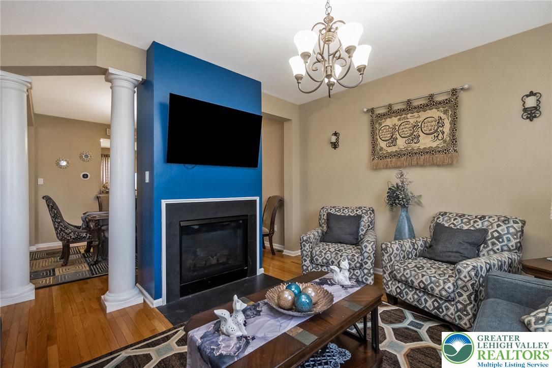3566 Penfield Way Nazareth, PA 18064 - Photo 21 of 47 Warm hardwood flooring guides you through this inviting living area featuring a fireplace and classic columns.