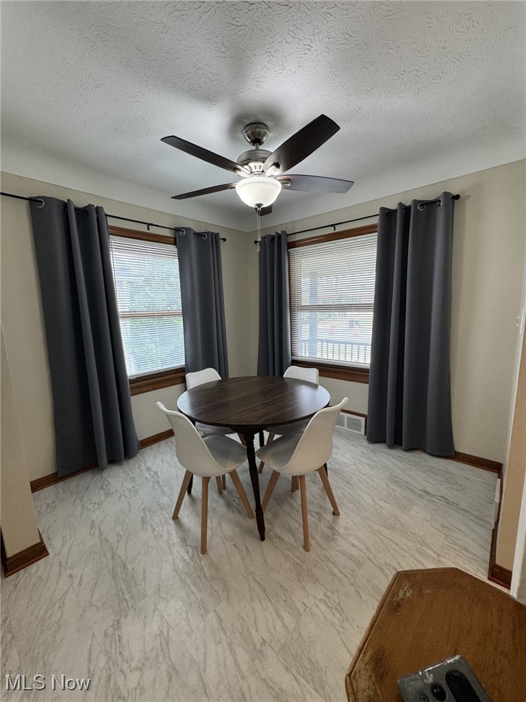 3712 Snow Road Cleveland, OH 44134 - Photo 7 of 40 Dining area featuring a ceiling fan, a textured ceiling, and light marble finish flooring