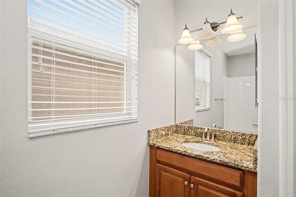 a bathroom with a granite countertop sink and a mirror