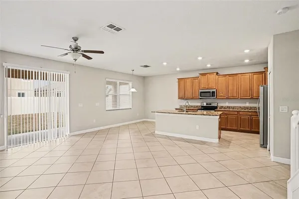 a kitchen with stainless steel appliances kitchen island granite countertop a refrigerator and a sink
