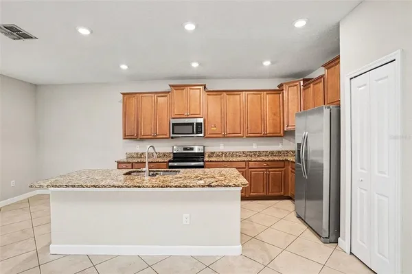 a kitchen with stainless steel appliances granite countertop a refrigerator stove microwave and sink