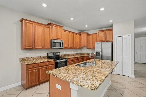a kitchen with stainless steel appliances granite countertop a sink stove and refrigerator