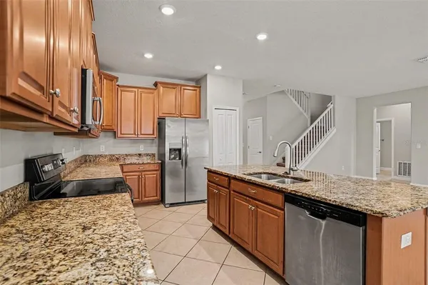 a kitchen with stainless steel appliances granite countertop a sink stove and refrigerator