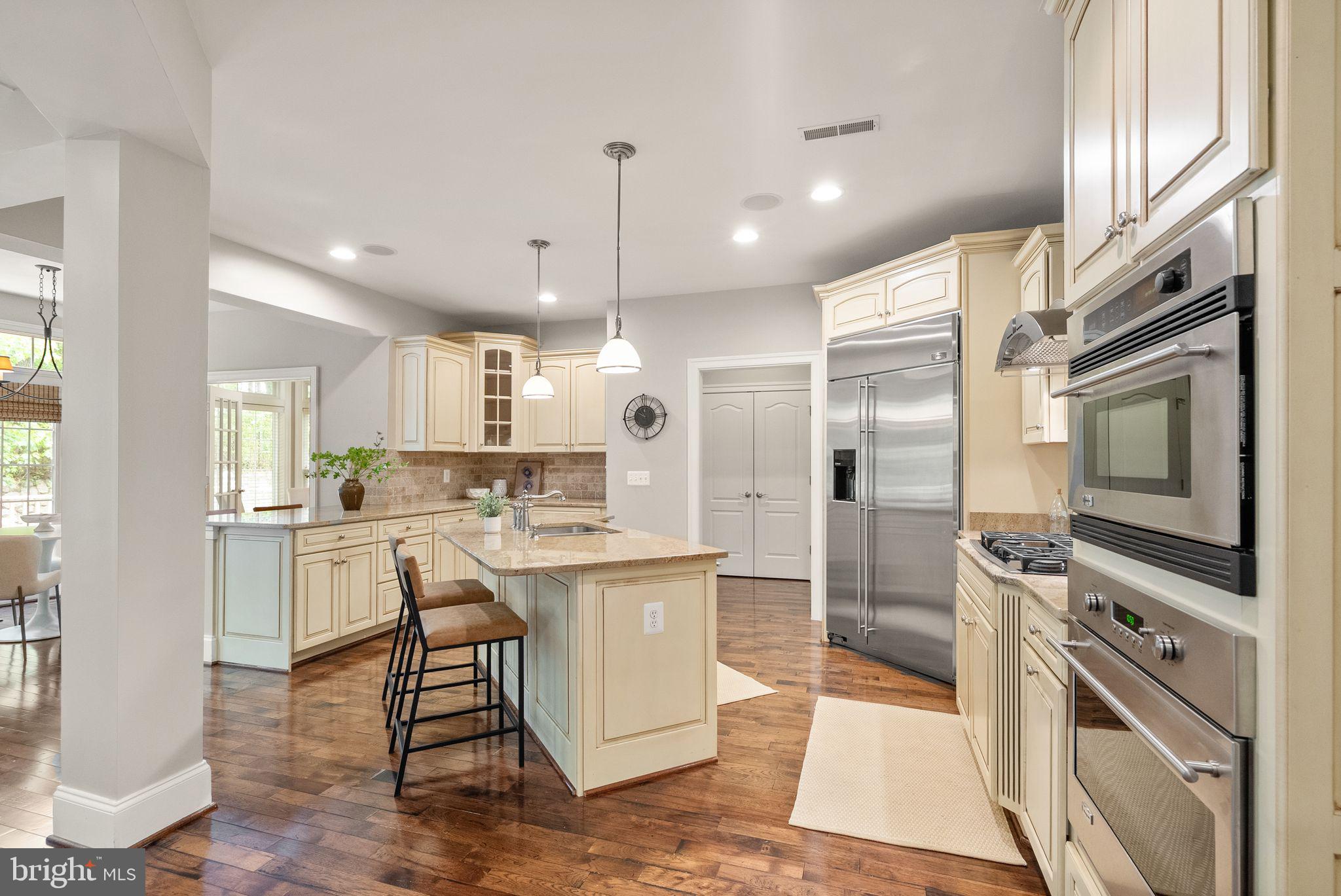 7534 Red Hill Drive Springfield, VA 22153 - Photo 16 of 90 a kitchen with stainless steel appliances kitchen island granite countertop a stove a sink a refrigerator and white cabinets with wooden floor