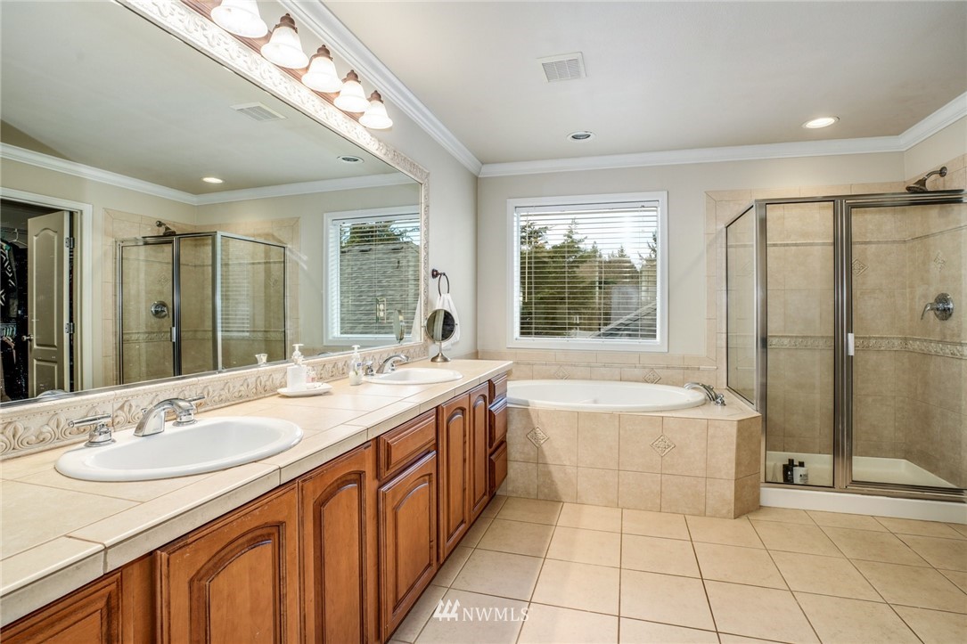 4113 Northeast 27th Place Renton, WA 98059 - Photo 19 of 27 a spacious bathroom with a granite countertop tub sink shower and mirror