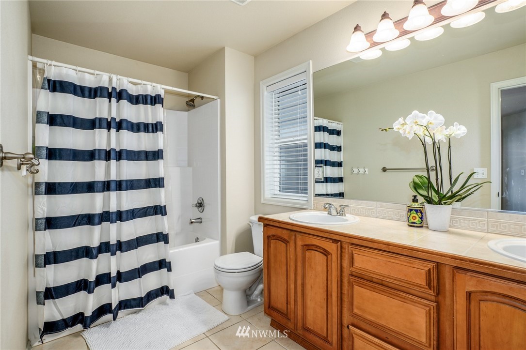 4113 Northeast 27th Place Renton, WA 98059 - Photo 21 of 27 a bathroom with a sink a toilet a large mirror and shower