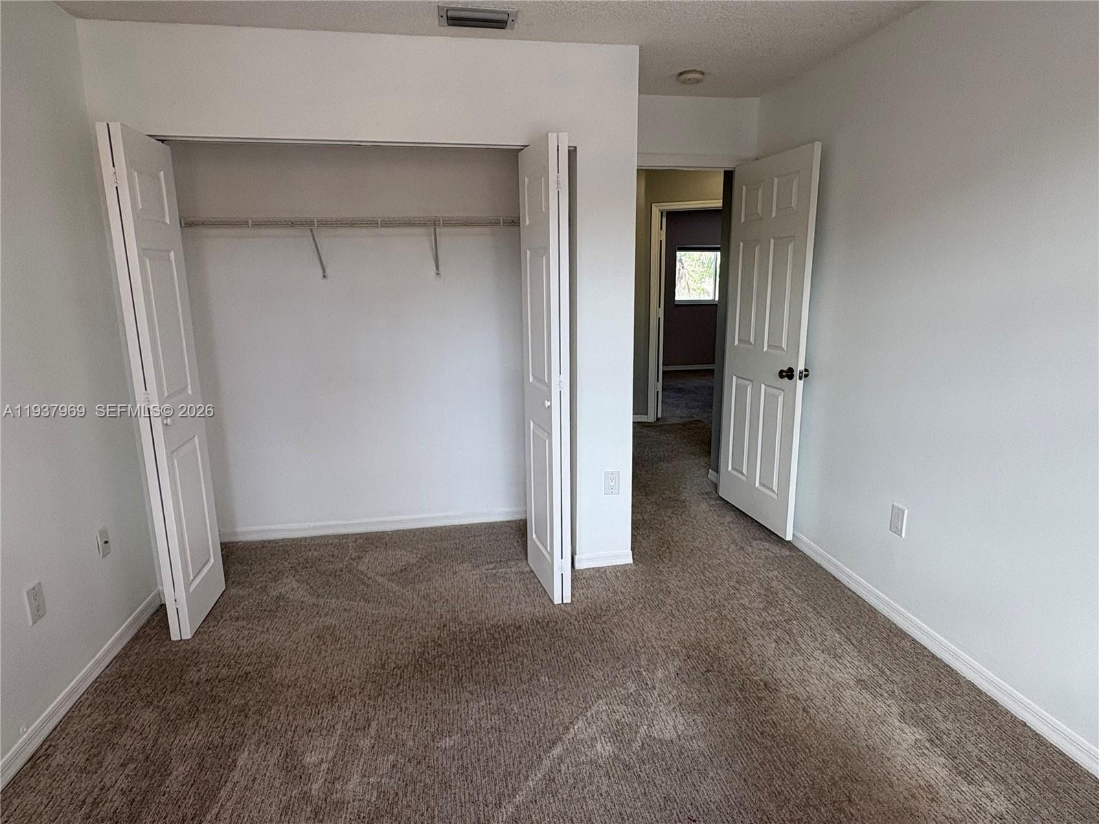 117 Danielle Court Weston, FL 33326 - Photo 22 of 43 a view of an empty room with closet and wooden door