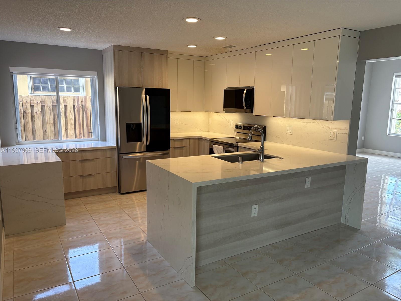 117 Danielle Court Weston, FL 33326 - Photo 7 of 43 a kitchen with kitchen island sink and refrigerator