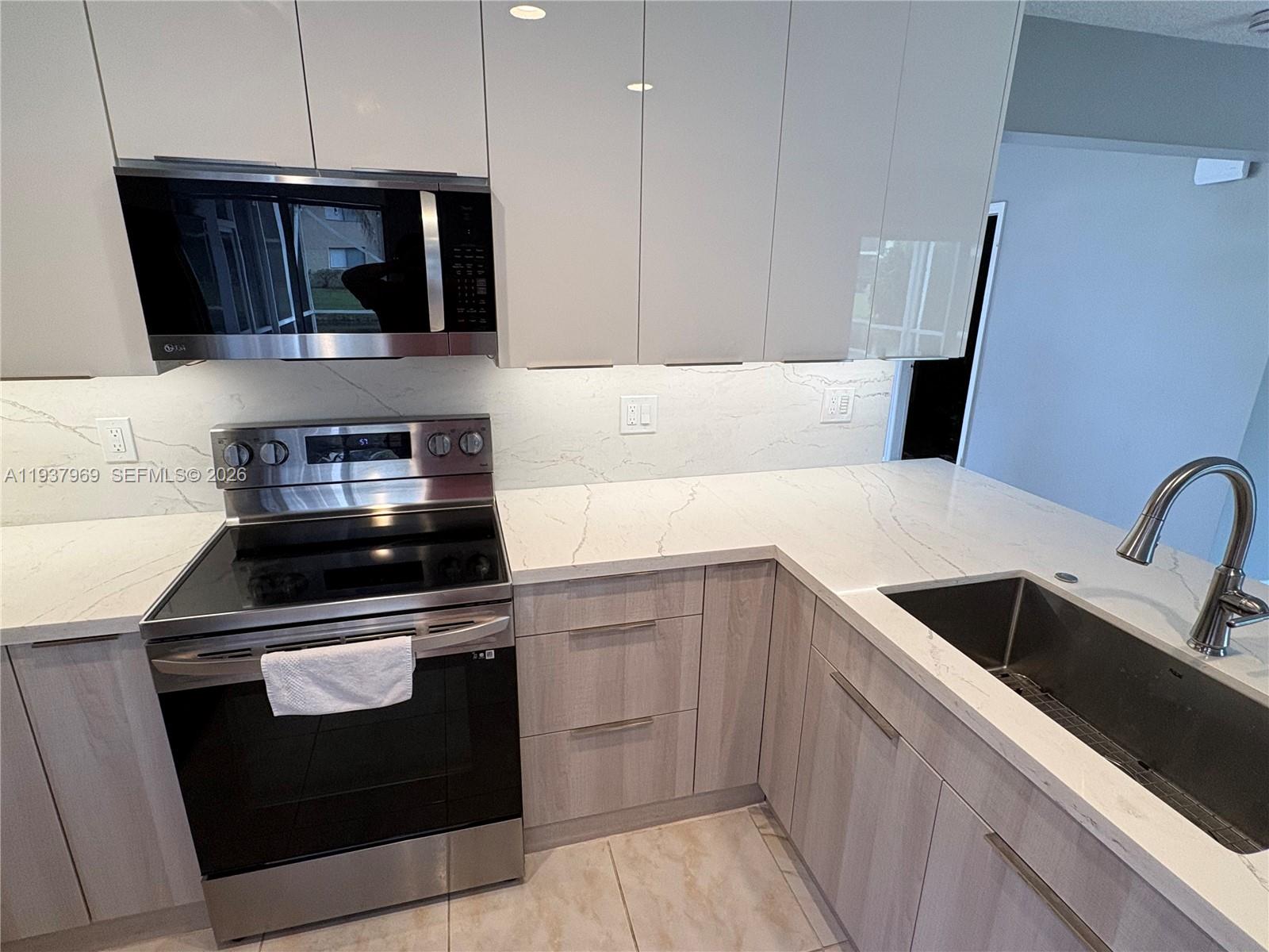 117 Danielle Court Weston, FL 33326 - Photo 9 of 43 a kitchen with a stove microwave and sink