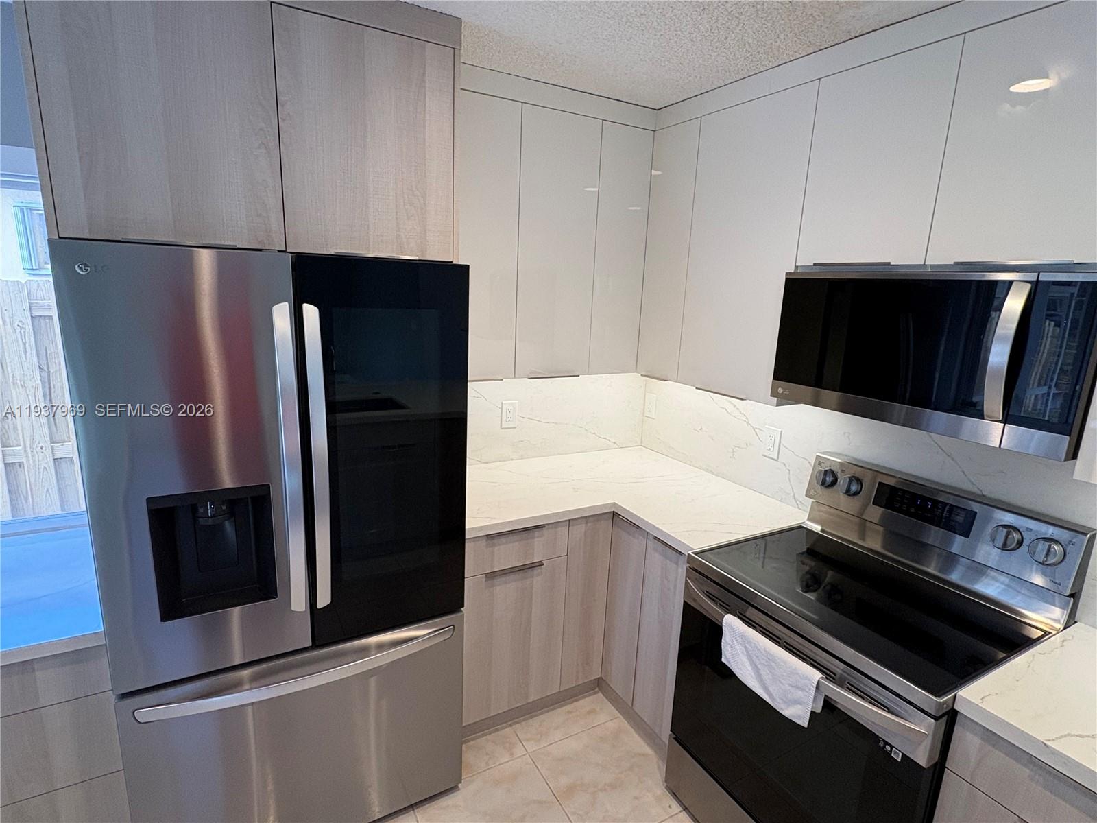 117 Danielle Court Weston, FL 33326 - Photo 10 of 43 a kitchen with stainless steel appliances a refrigerator a stove and a microwave