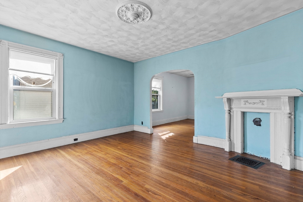 66 Round Hill Street Boston, MA 02130 - Photo 3 of 17 a view of an empty room with wooden floor and a window