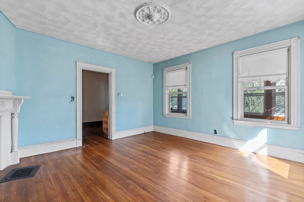66 Round Hill Street Boston, MA 02130 - Photo 4 of 17 an empty room with wooden floor and windows