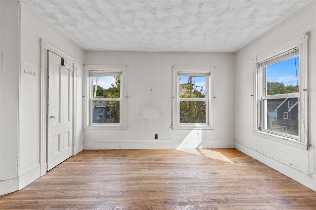 66 Round Hill Street Boston, MA 02130 - Photo 7 of 17 a view of an empty room with wooden floor and a window