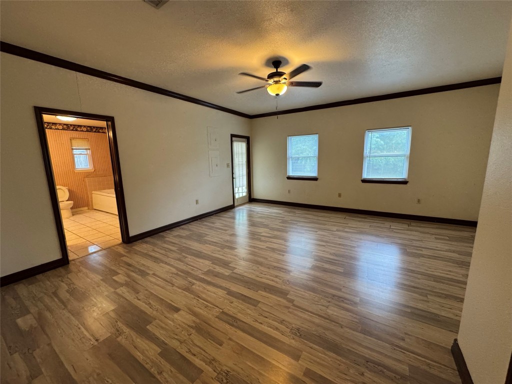 5054 Old Goforth Road Buda, TX 78610 - Photo 16 of 28 a view of an empty room with wooden floor and a ceiling fan