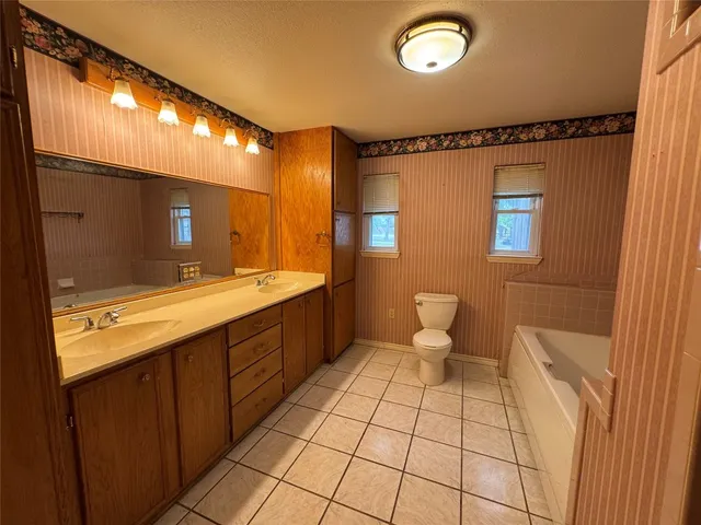 a bathroom with a sink a toilet and mirror