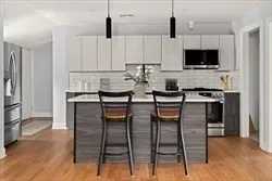 a kitchen with stainless steel appliances kitchen island granite countertop a table and chairs in it