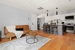 a living room with lots of furniture and kitchen view
