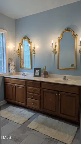 a bathroom with a double vanity sink and a mirror