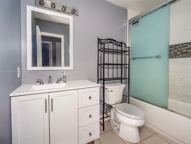a bathroom with a toilet sink vanity and mirror