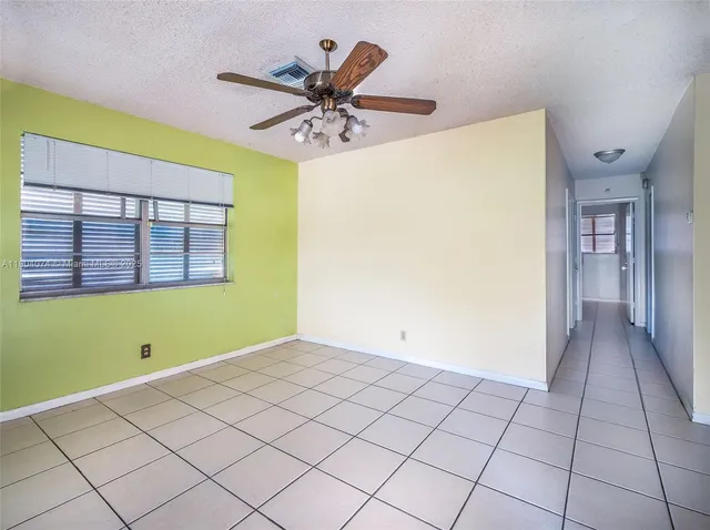 a view of a room with window a ceiling fan and front door