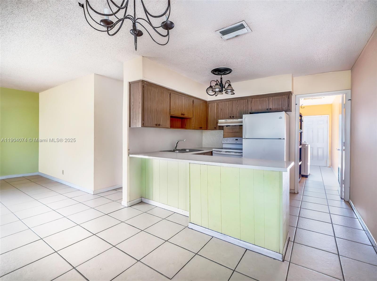 6510 Southwest 49th Street Davie, FL 33314 - Photo 7 of 26 a kitchen with a refrigerator and a sink