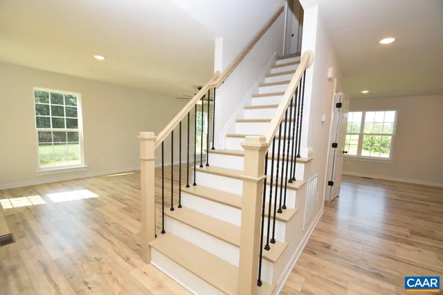 a view of a hallway with wooden floor and windows