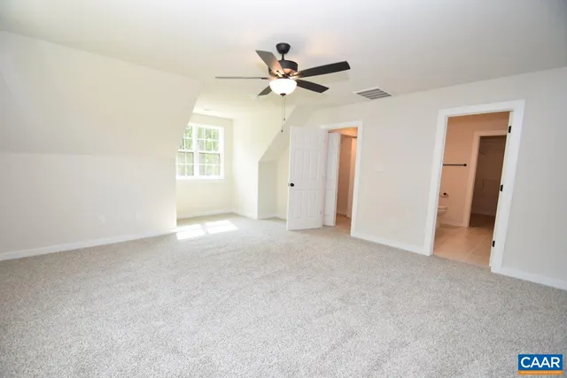 an empty room with a ceiling fan and window