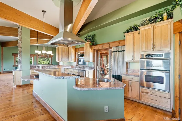 a living room with furniture a large window and chandelier