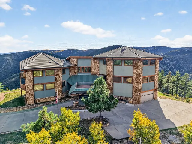 a view of a house with a big yard and large trees