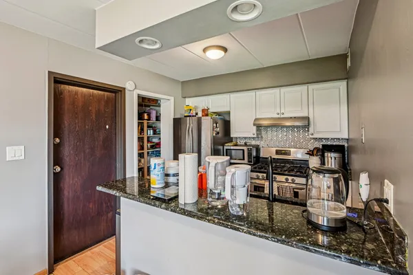 a kitchen with stainless steel appliances granite countertop a refrigerator and a stove