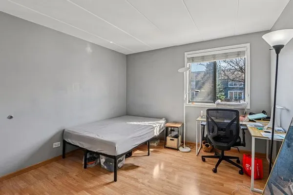a bed room with a bed a desk and a window