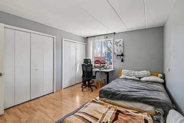 a bedroom with a bed and a wooden floor
