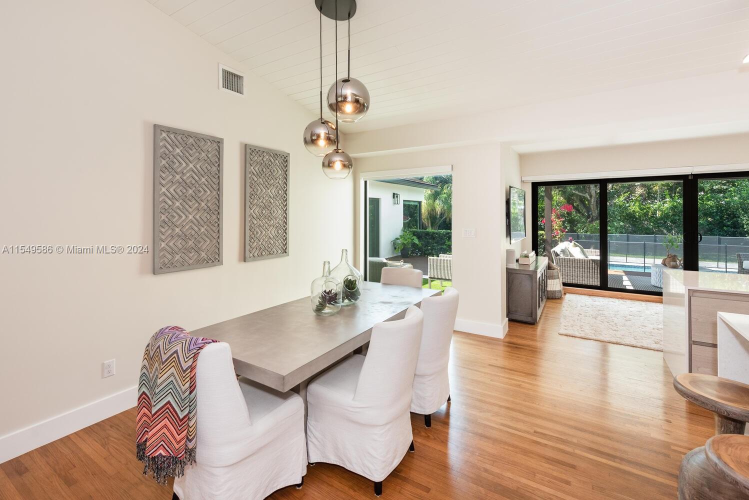 520 Southwest 27th Road Miami, FL 33129 - Photo 13 of 50 a view of a dining room with furniture wooden floor and chandelier
