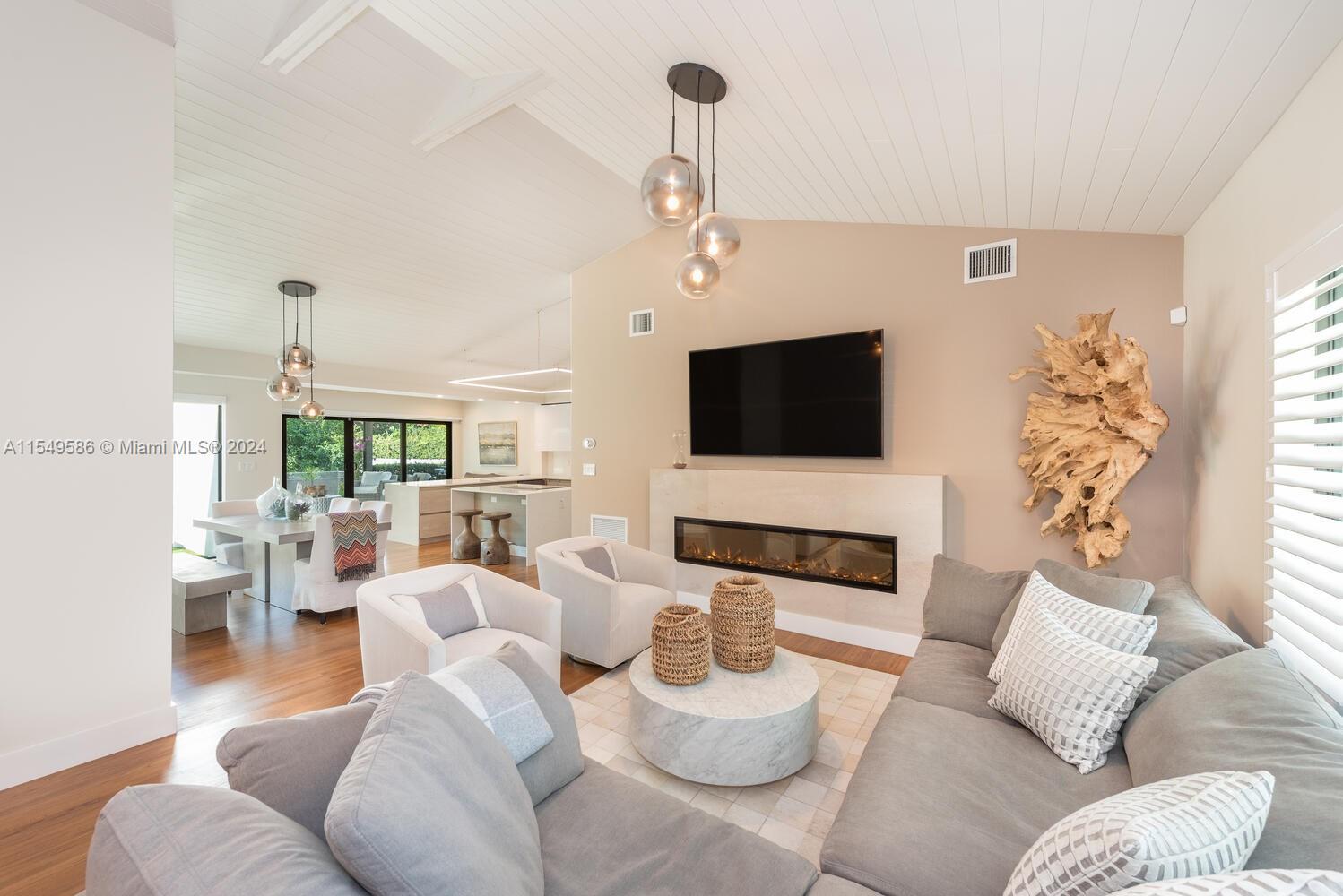 520 Southwest 27th Road Miami, FL 33129 - Photo 5 of 50 a living room with furniture a flat screen tv and a chandelier
