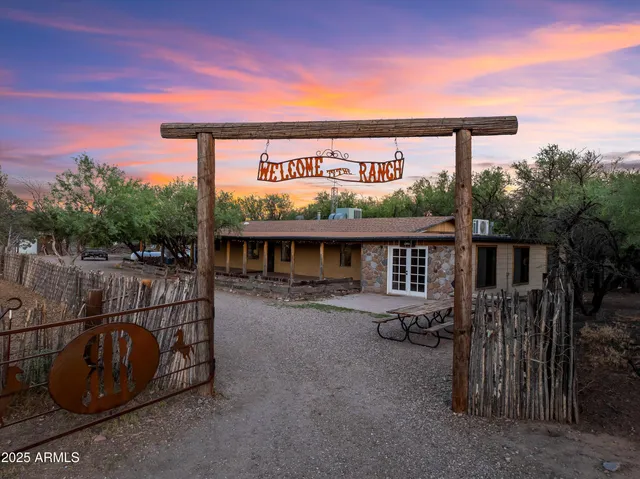 a view of a dry yard with wooden fence