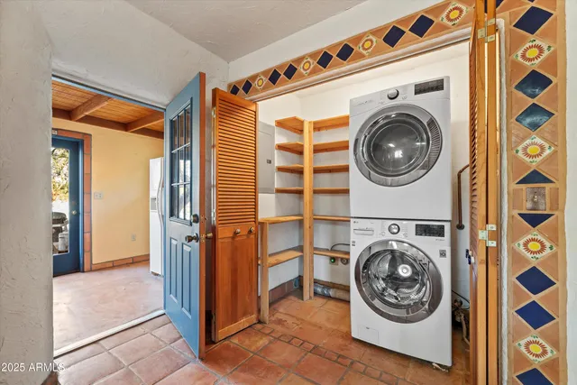 a kitchen with stainless steel appliances granite countertop wooden cabinets a sink a stove a dining table and chairs