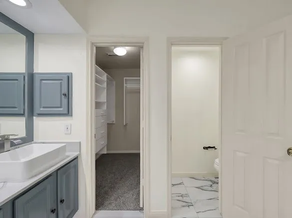 an empty room with chandelier fan and windows